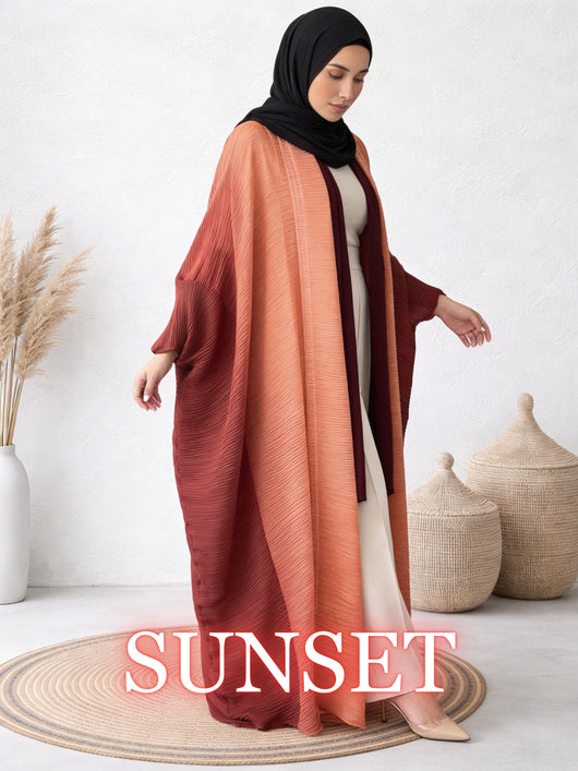 Woman wearing Sultana sunset abaya with warm gradient tones and fluid drape