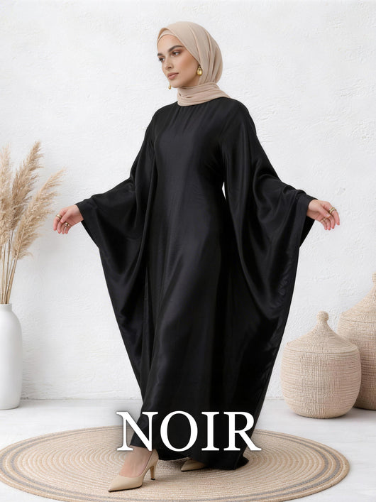 Woman wearing Yasmin abaya in noir with fluid satin drape and batwing sleeves