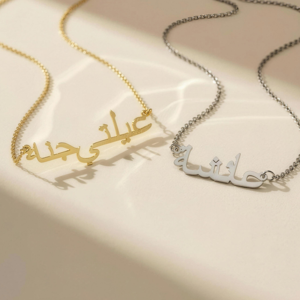 Zahria Arabic name necklaces in gold and silver on sunlit surface