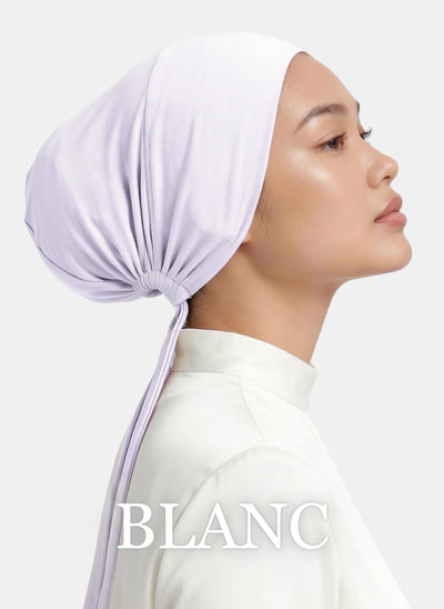 Side-angle product photo of the Zeenah Silk Undercap in Blanc on a model.