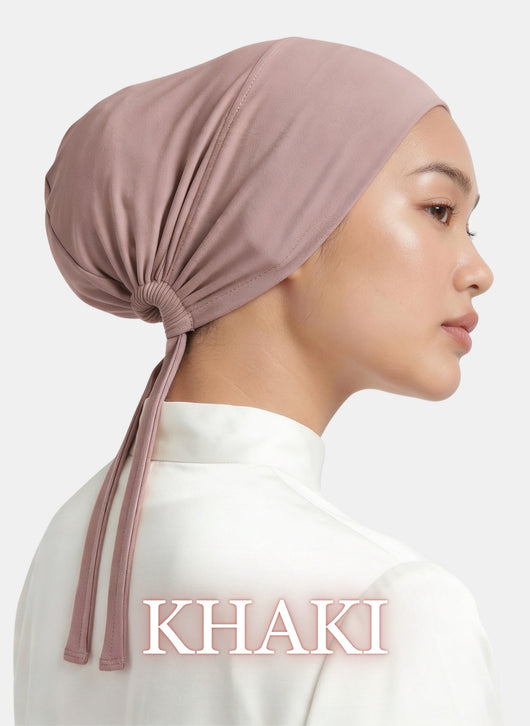 Model wearing the Zeenah Silk Undercap in Khaki, featuring a smooth fit and adjustable tie-back design.
