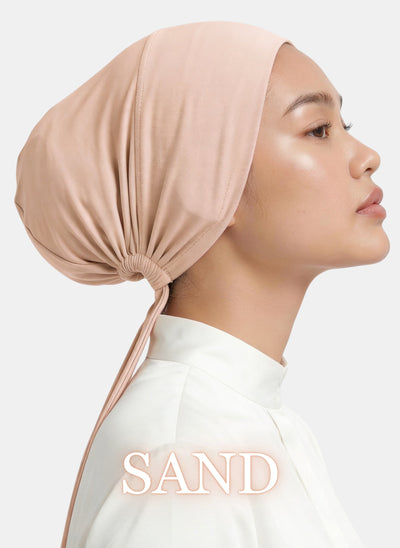 Model showcasing the Zeenah Silk Undercap in Sand, viewed from the side.